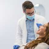 Endodontist examining woman with dental equipments