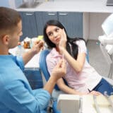 Women with a toothache because of infected root canal visiting the endodontist office