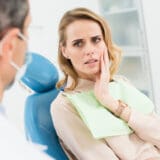 Female patient concerned about toothache in endodontist clinic